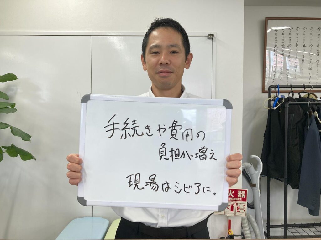 アスベストついて解説し、ホワイトボードを持つ初田理事