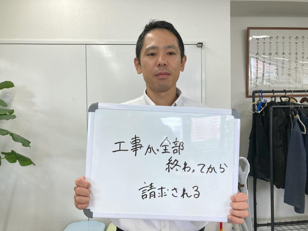 トラブル事例について解説し、ホワイトボードを持つ初田理事