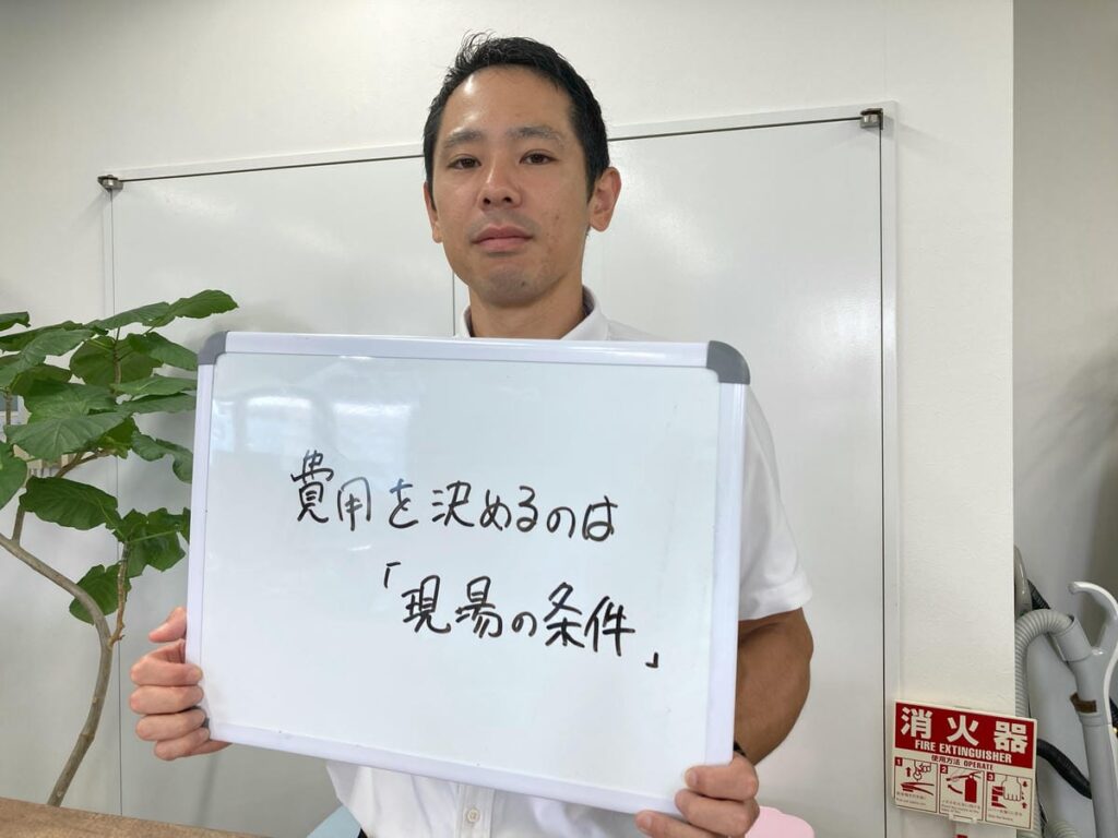 店舗解体の費用について解説し、ホワイトボードを持つ初田理事