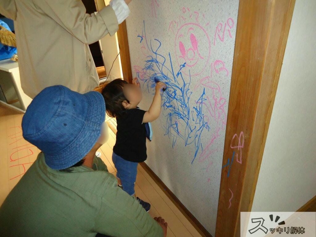 解体前の実家の壁に落書きする様子