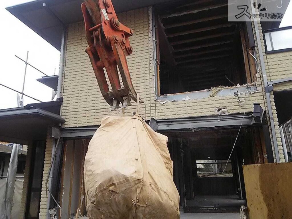 スケルトン解体 廃棄物をクレーンで窓から下ろしている様子