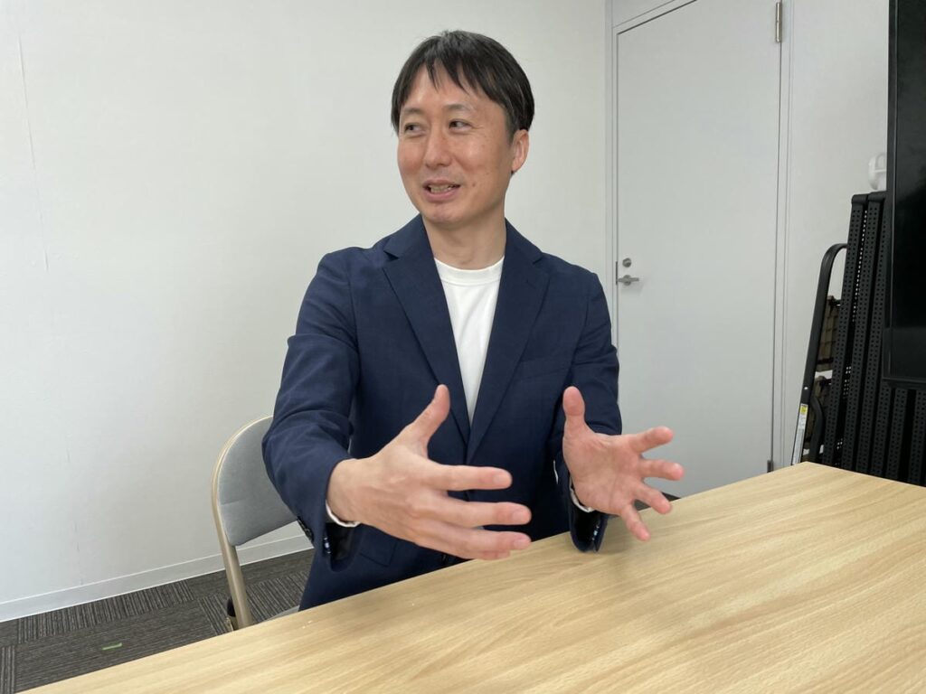 インタビューに受け答えする中野理事