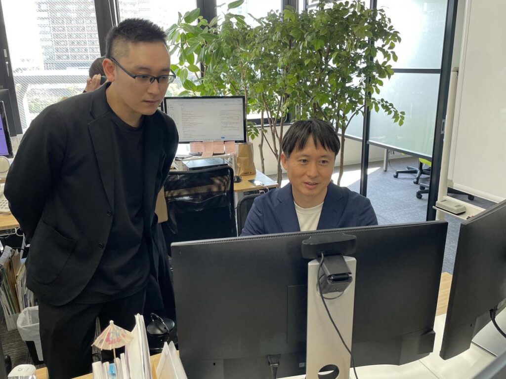 パソコンを使って稲垣に説明する中野理事