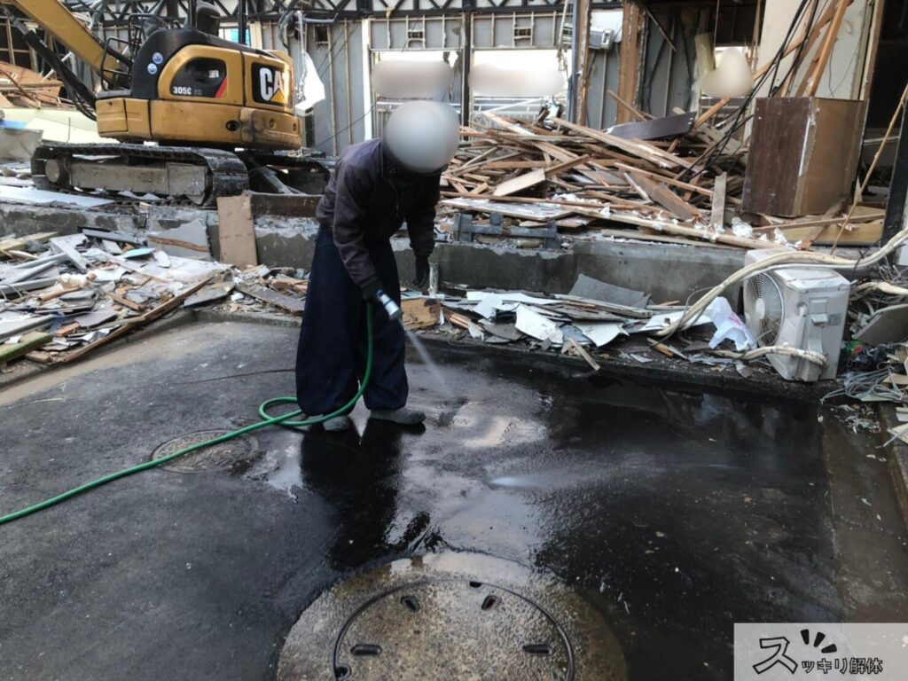 雨の日の解体工事中に清掃を行う業者