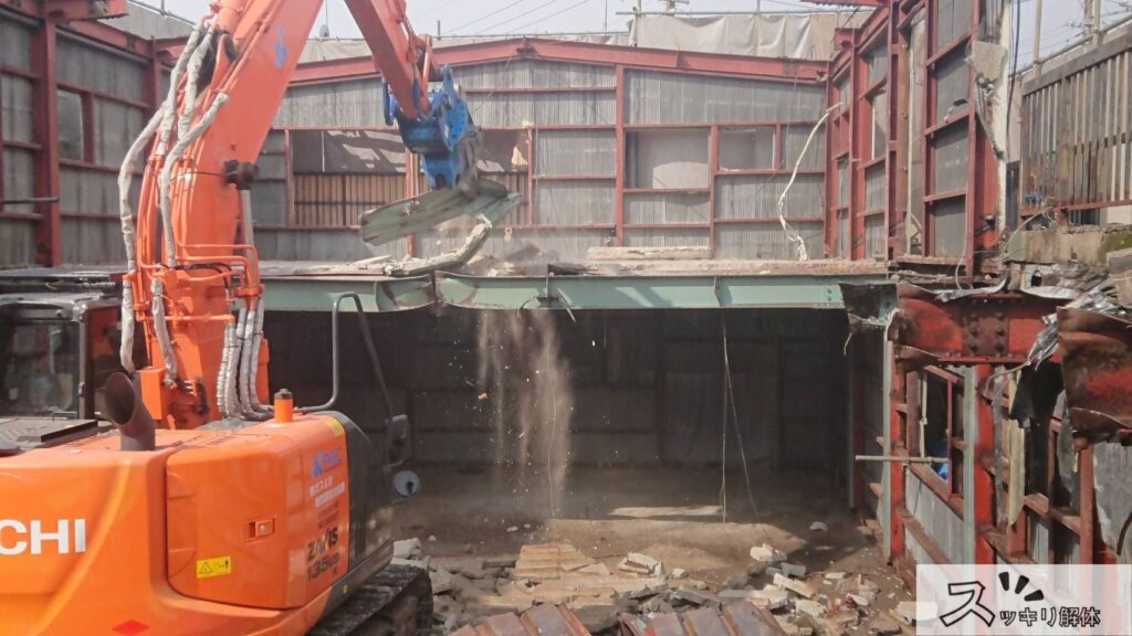 重機で鉄骨造の建物を取り壊す様子