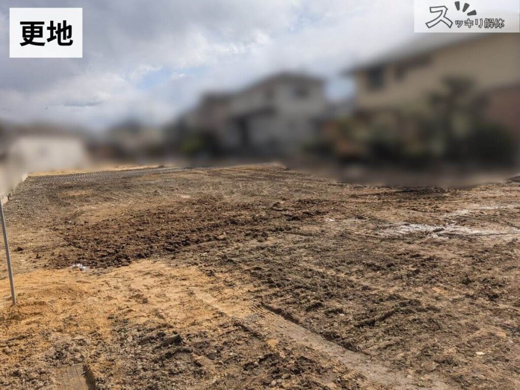 住宅の解体後に建物が取り除かれ、重機の跡が残る土の地面の更地。