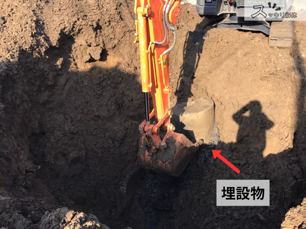 整地作業中に出現した地中埋設物を重機で発掘している現場の様子
