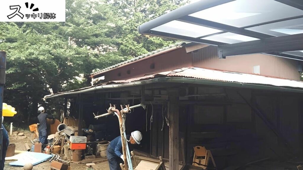 解体業者が納屋入口付近の残置物を撤去する様子
